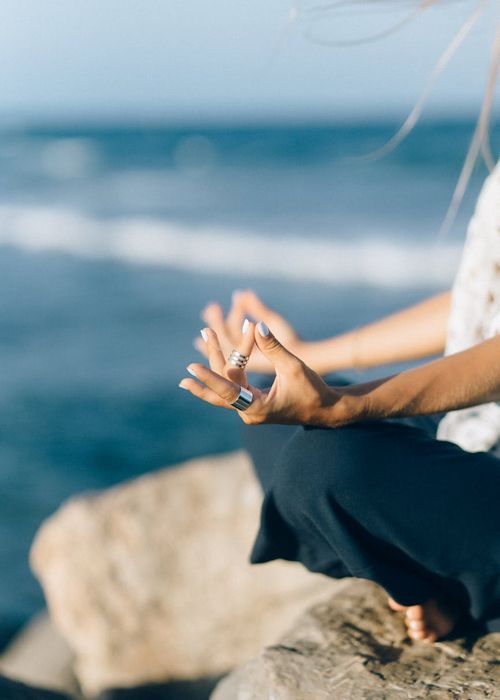 Close-up shot of hands in a specific yoga mudra, showing concentration.